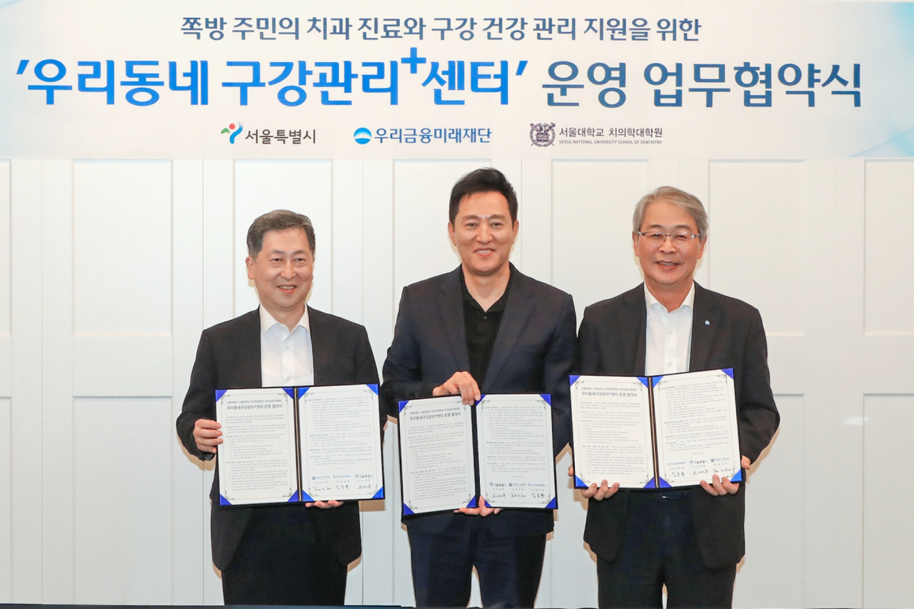서울시는 1일 오후 ‘서울역 쪽방촌’으로 불리는 용산구 동자동에 ‘우리동네구강관리 플러스센터’ 2호점 개소식을 가졌다. 임종룡 우리금융그룹 회장(오른쪽), 오세훈 서울시장, 권호범 서울대학교 치의학대학원 원장이 업무협약 후 기념촬영을 하고 있다.[우리금융그룹 제공]