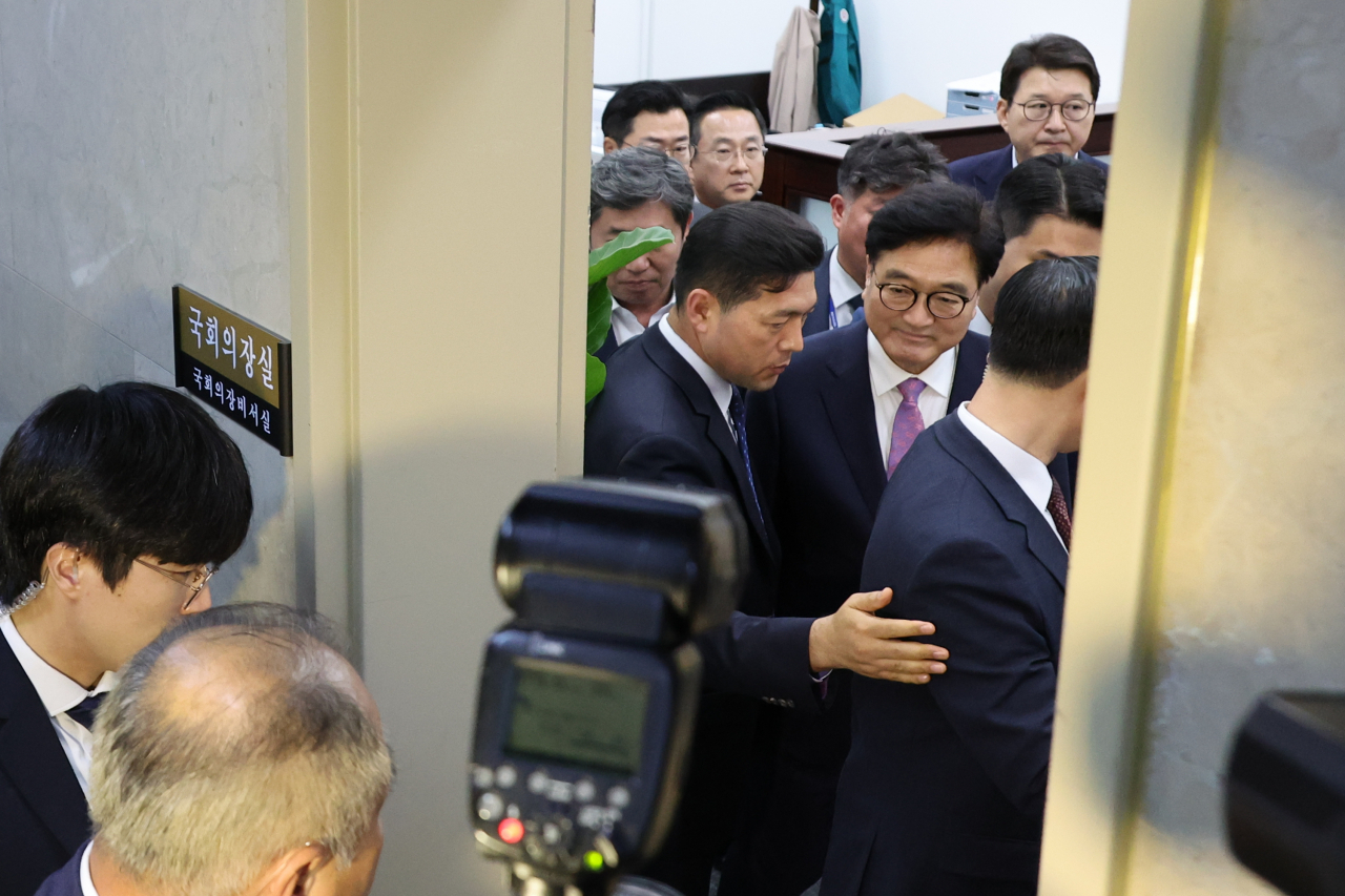 우원식 국회의장이 대정부질문을 앞둔 2일 오후 국민의힘 의원들의 사퇴요구를 받으며 집무실에서 나와 본회의장으로 향하고 있다. 이날 국민의힘 의원들은 의원총회를 마친 뒤 국회의장실을 항의방문해 채상병 특검법을 상정하려는 우원식 의장의 사퇴를 촉구했다. [연합]