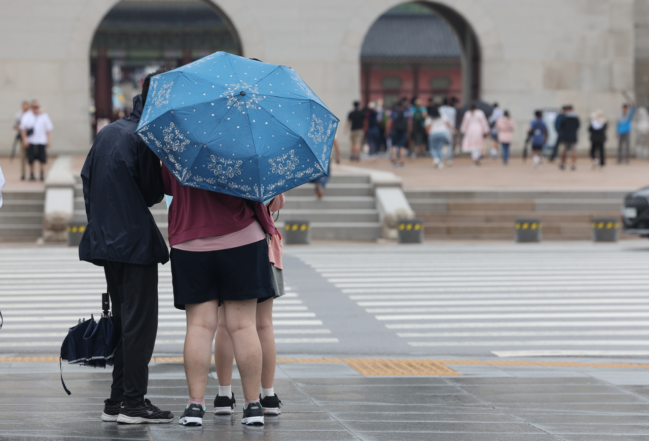 장마 영향으로 비가 내린 30일 오전 서울 종로구 광화문광장 일대에서 외국인 관광객들이 우산을 쓰고 이동하고 있다. [연합]