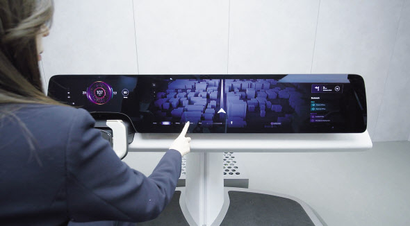LG디스플레이 직원이 차량용 P(플라스틱)-OLED P2P(필러투필러)가 탑재된 디지털 콕핏을 소개하고 있다. [LG디스플레이 제공]