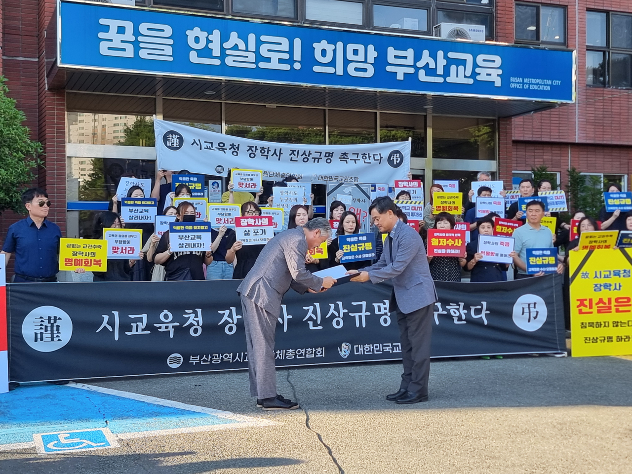 (앞줄 왼쪽부터) 강재철 부산시교원단체총연합회 회장이 정대호 부산시교육청 교육국장에게 성명서를 전달하고 있다. [사진=임순택 기자]