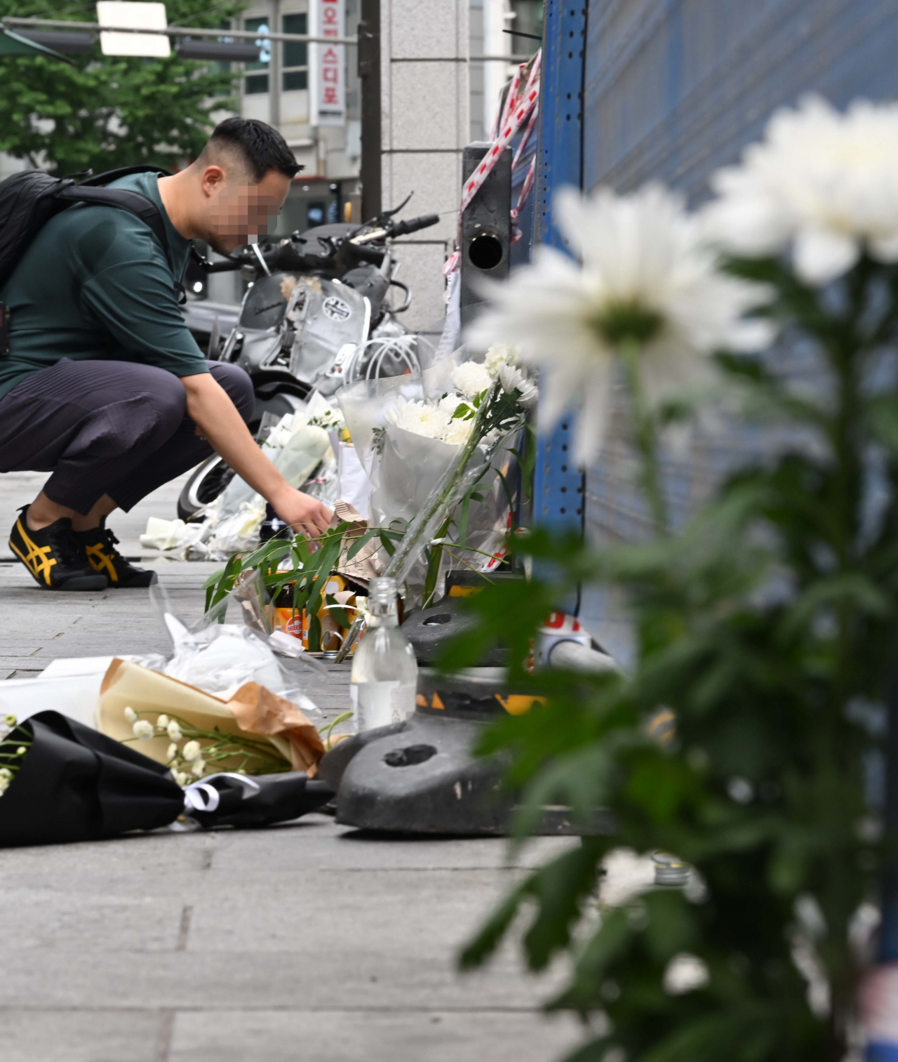 지난 1일 밤 승용차가 인도로 돌진해 9명이 사망하는 사고가 발생한 가운데 3일 오전 서울 중구 서울시청 인근 교차로 사고현장에서 한 시민이 희생자를 추모하며 헌화를 하고 있다. 이번 사고로 9명이 사망하고 4명(중상 1명·경상 3명)이 다쳤다. 사망자 9명 중 6명은 현장에서 사망했으며, 3명은 병원 이송 도중 사망했다. 이상섭 기자