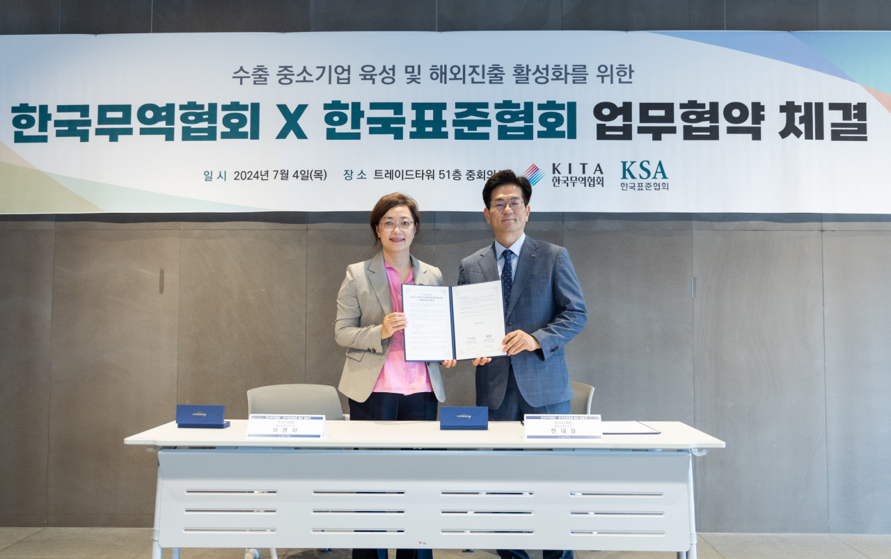 이명자(왼쪽) 한국무역협회 해외마케팅본부장과 한대철 한국표준협회 품질경영본부장이 4일 삼성동 트레이드타워에서 열린 중소기업 해외진출 공동지원을 위한 업무협약(MOU) 체결식에서 기념 촬영을 하고 있다. [한국무역협회 제공]