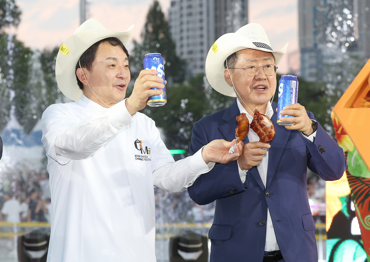홍준표(오른쪽) 대구시장이 30일 대구 달서구 두류공원 2·28 자유광장에서 개막한 '2024 대구치맥페스티벌' 개막식에서 국민의힘 원희룡(왼쪽) 당 대표 후보와 건배하고 있다. [연합]