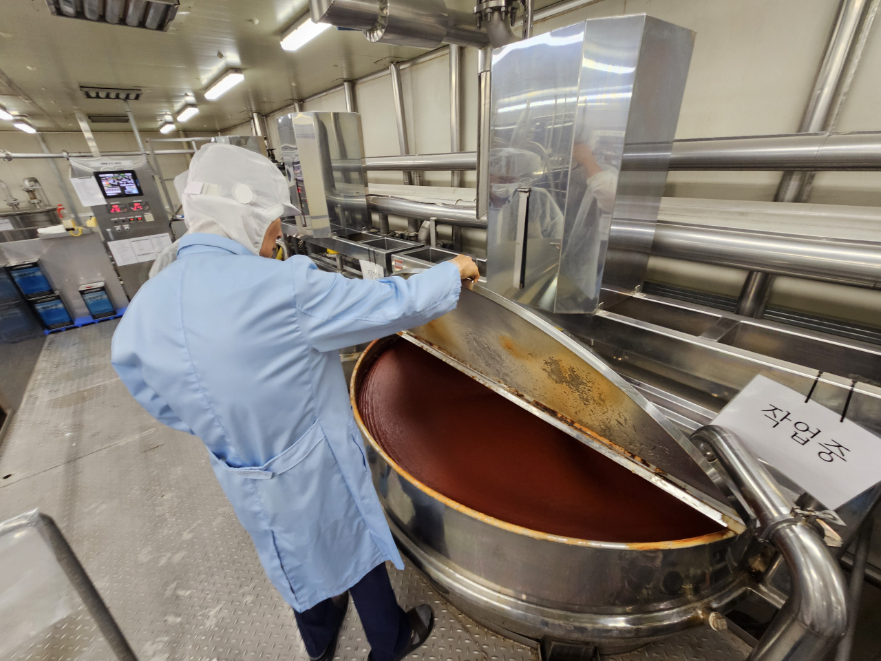 Woomtree‘s founder and CEO Kim Woo-taek examines the fermenting process of gochujang sauce at the firm’s factory in Pocheon, Gyeonggi Province, on Thursday. (Kim Hae-yeon/ The Korea Herald)