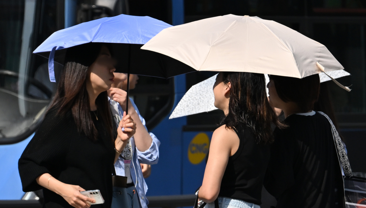 서울 종로구 세종대로 사거리에서 시민들이 양산으로 햇빛을 가리며 출근길을 서두르고 있다. 임세준 기자