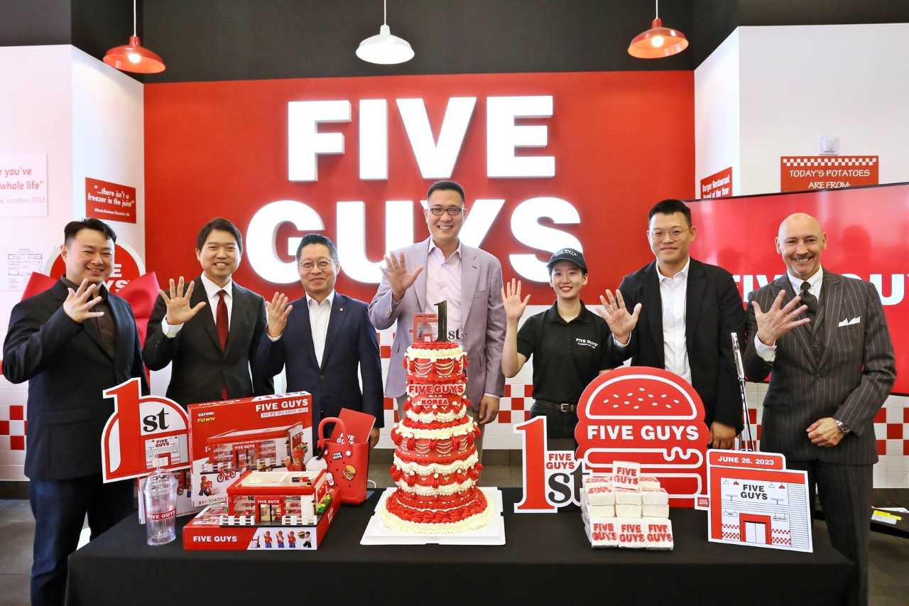 6월 26일 국내 론칭 1주년을 맞아 1호점인 파이브가이즈 강남에서 김동선 부사장(가운데)을 비롯한 주요 관계자들이 케이크 커팅식을 하고 있다. [한화갤러리아 제공]