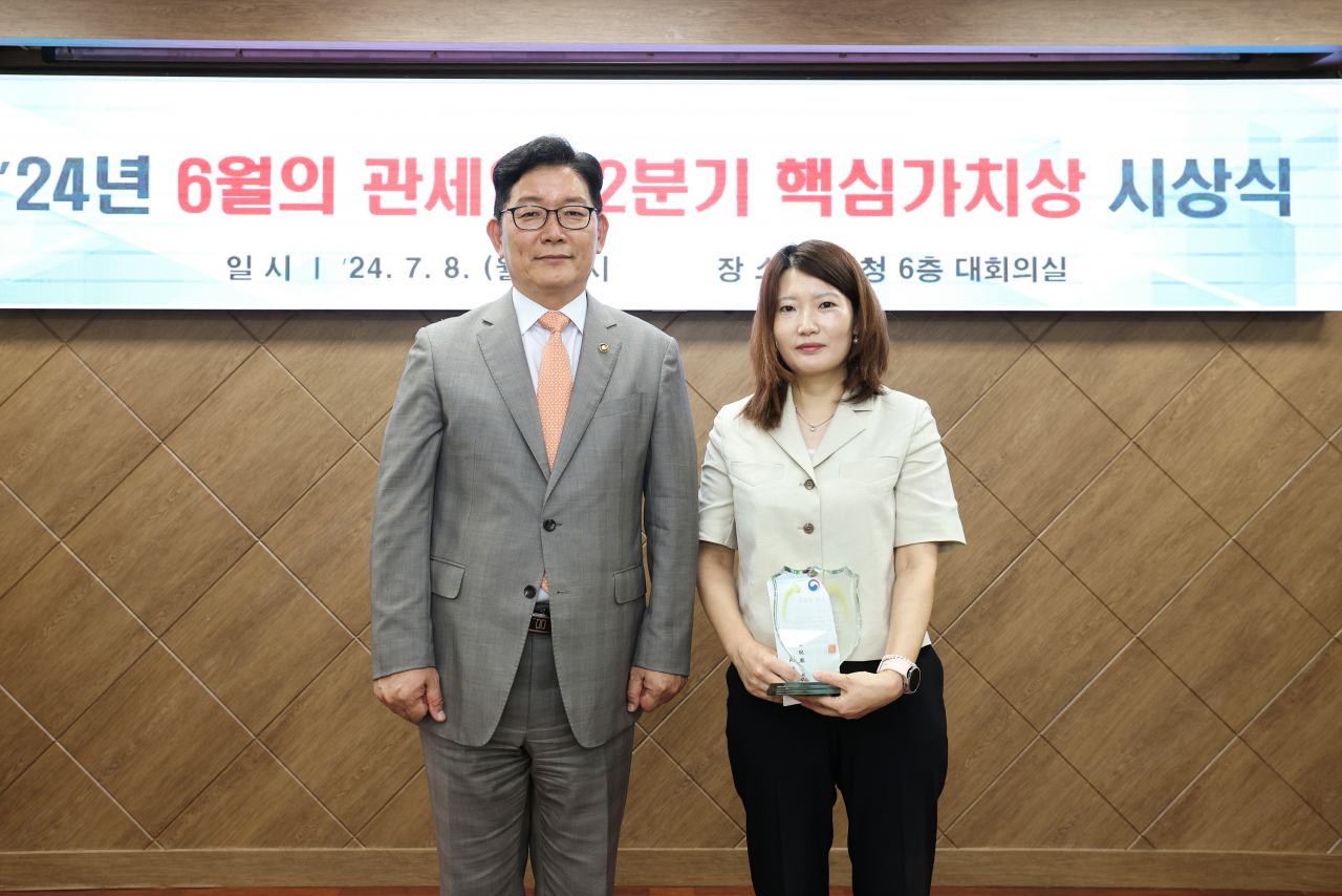 고광효 관세청장(왼쪽)이 8일 본청 대회의실에서 6월의 관세인에 선정된 서울세관 신지애 주무관과 기념촬영하고 있다.