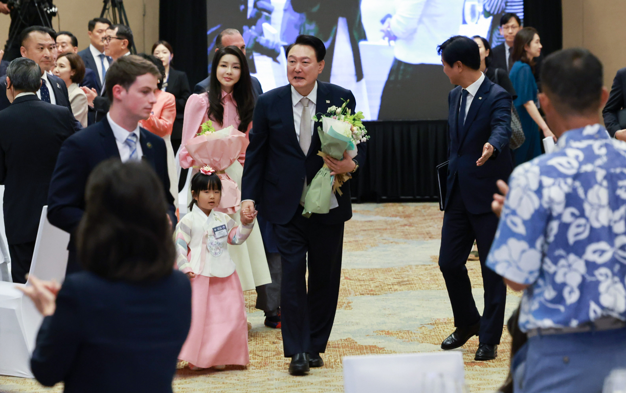 윤석열 대통령과 김건희 여사가 8일(현지시간) 미국 하와이 호놀룰루 쉐라톤 와이키키 호텔에서 열린 동포간담회에서 화동의 손을 잡고 입장하고 있다. [연합]