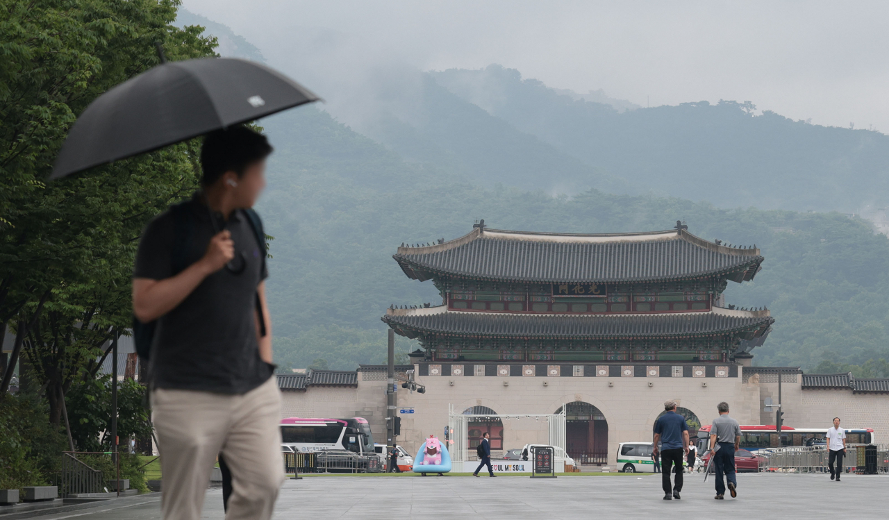 장맛비가 내리는 8일 오전 서울 종로구 광화문광장에서 출근길 시민들이 발걸음을 옮기고 있다. [연합]
