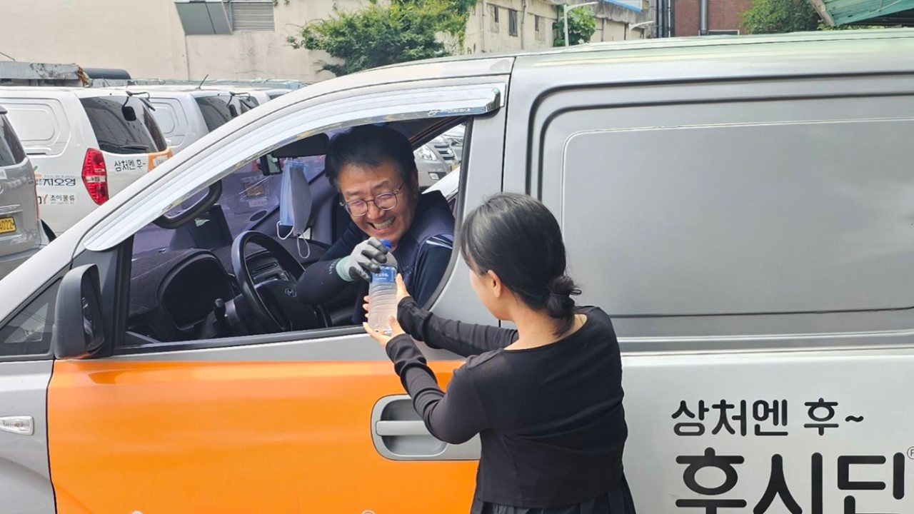 지오영 직원이 배송기사에게 얼음생수를 전달하고 있다. 지오영 제공