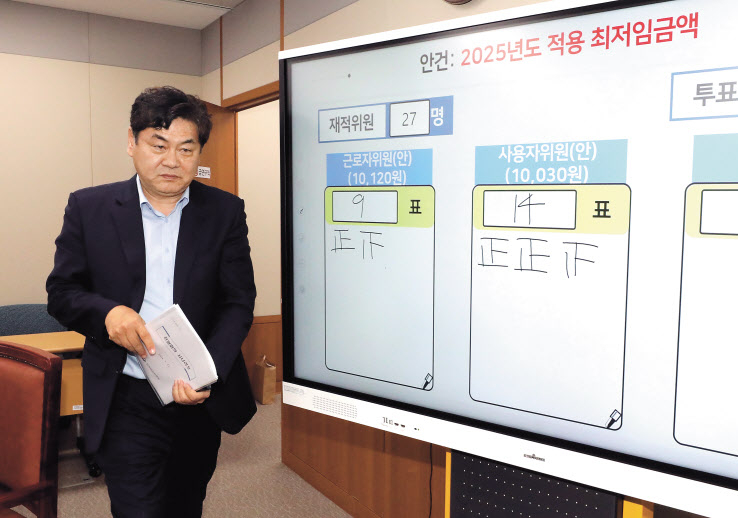 이인재 최저임금위원장이 12일 새벽 정부세종청사에서 열린 제11차 전원회의에서 노사 양측 최종안의 표결을 거쳐 내년 최저임금을 시간당 1만30원으로 결정한 뒤 퇴장하고 있다. [연합]