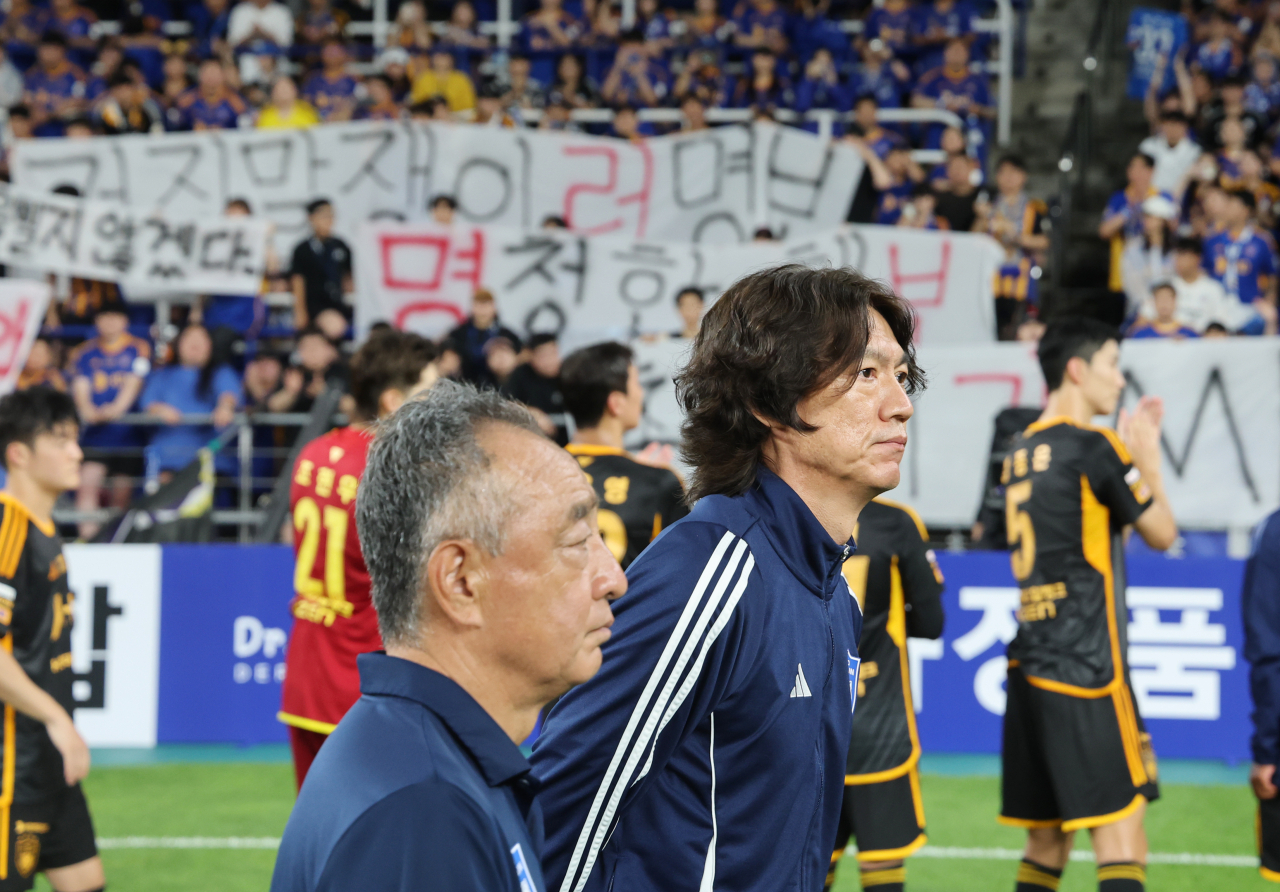10일 오후 울산 문수축구경기장에서 축구 국가대표팀 감독으로 내정된 울산 HD 홍명보 감독이 광주FC와의 경기 후 자신을 비판하는 걸개가 내걸린 서포터스석 옆을 지나가고 있다. [연합]