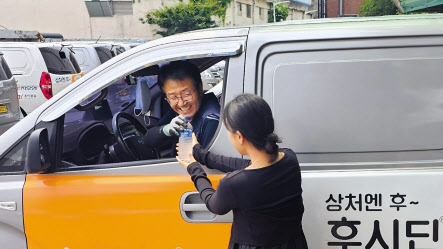 지오영 직원이 배송기사에게 얼음생수를 전달하고 있다. [지오영 제공]