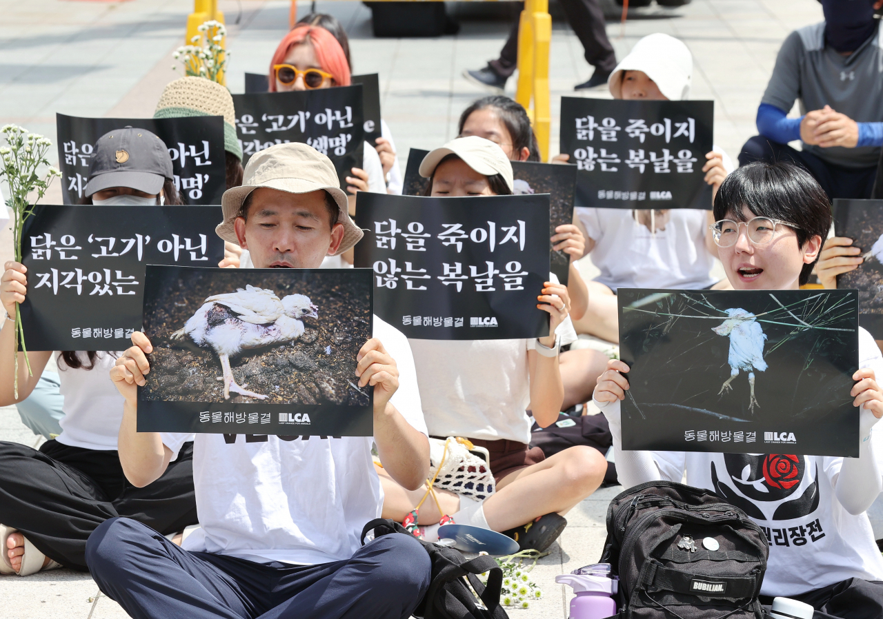 초복인 15일 오전 서울 종로구 보신각 앞에서 동물해방물결 주최로 열린 '2024 복날추모행동' 집회에서 참석자들이 손팻말을 들고 구호를 외치고 있다. [연합]