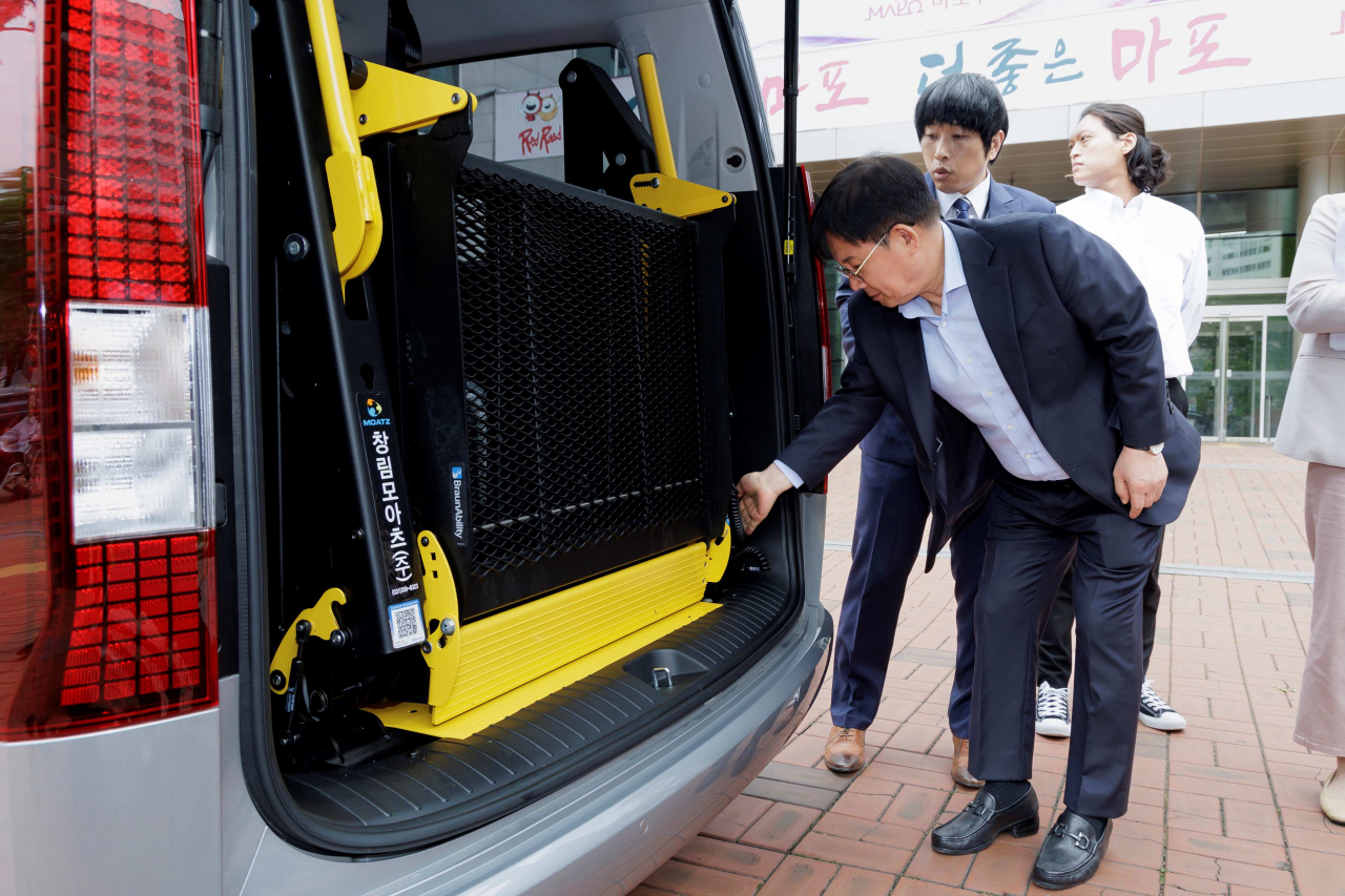 박강수 마포구청장이 국제라이온스에서 기탁한 뇌병변장애인 특수차량 내부를 꼼꼼히 살펴보고 있다.[마포구 제공]