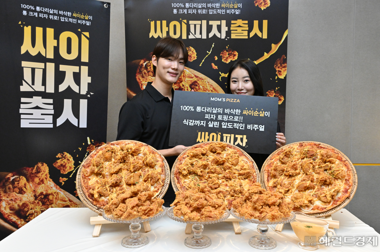 맘스터치의 피자브랜드 맘스피자가 16일 오전 서울 중구 맘스피자 DDP점에서 크리스피 치킨 피자 ‘싸이피자’ 출시행사를 진행한 가운데 모델들이 제품을 선보이고 있다. 맘스피자가 새롭게 선보이는 ‘싸이피자’는 100% 통다리살, 스모키 바비큐 소스, 씬 크러스트 도우가 조합된 프리미엄 피자다. 임세준 기자