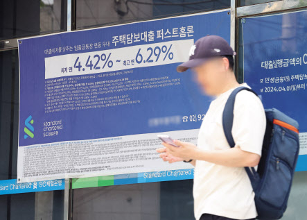 서울 한 시중은행 영업점의 대출 안내문 앞을 시민이 지나가고 있다. [연합]