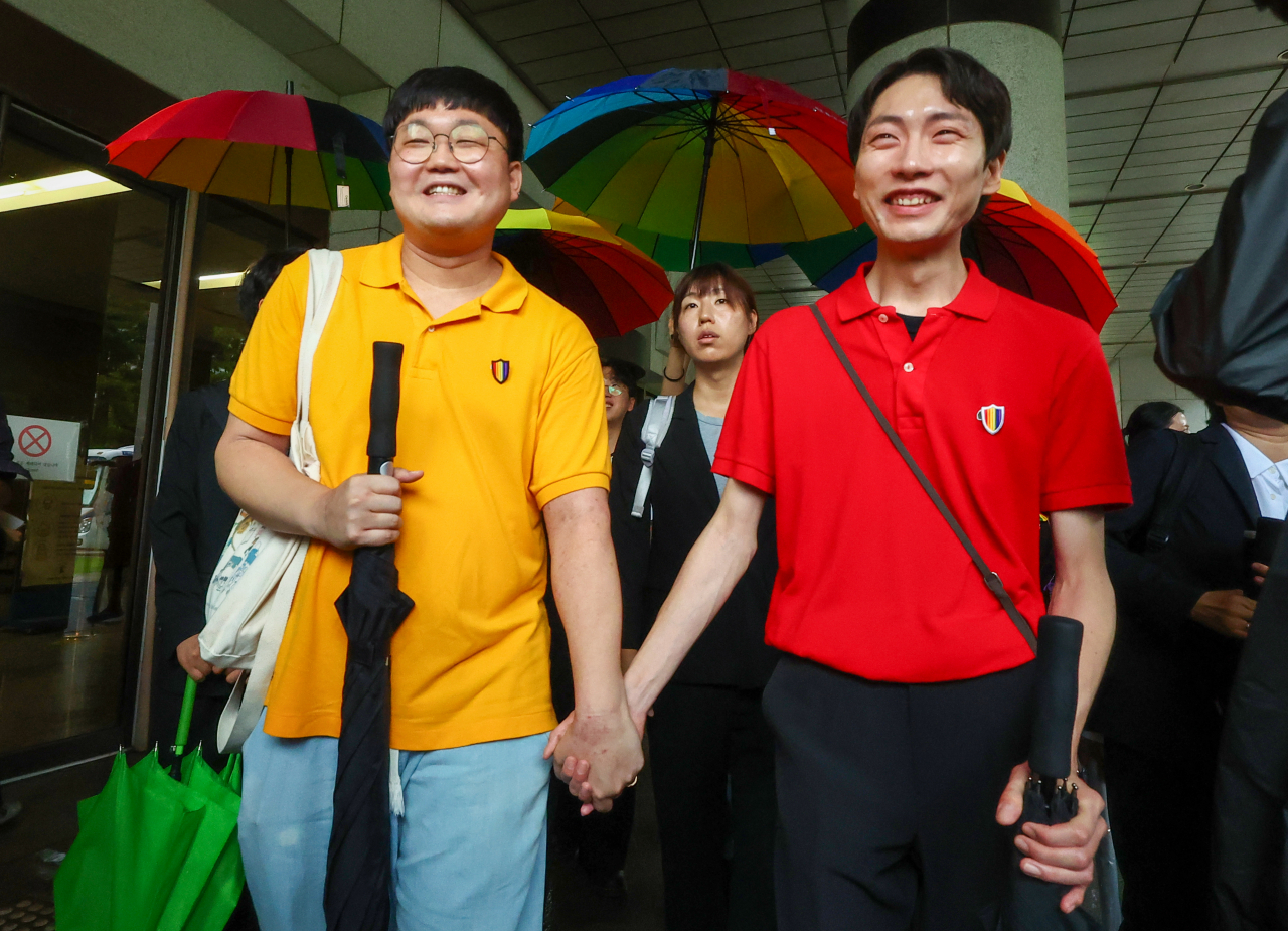 동성 연인 건강보험 피부양자 자격과 관련해 국민건강보험공단을 상대로 제기한 보험료 부과 처분 취소 소송에서 승소한 소성욱씨와 김용민씨(오른쪽)가 손을 잡고 밝은 표정으로 서울 서초구 대법원을 떠나고 있다. [연합]