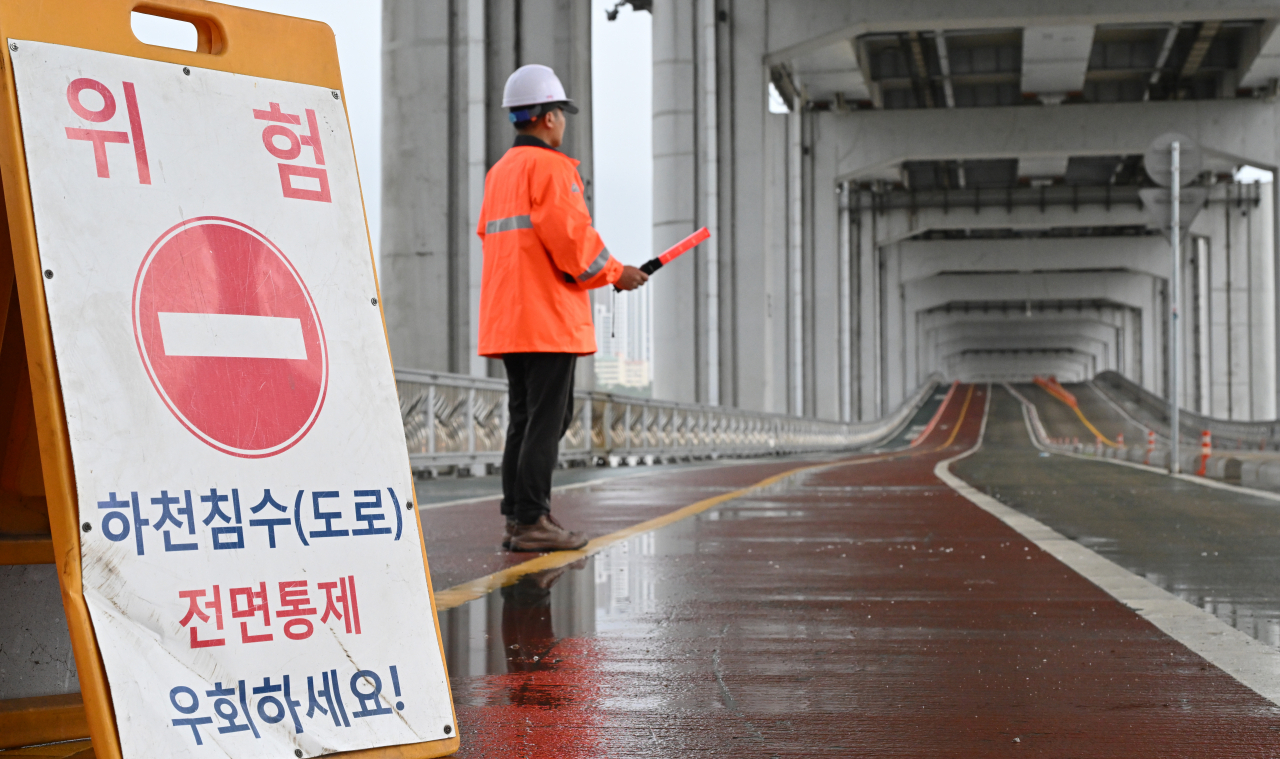 중부지방에 집중호우가 이어지고 있는 18일 오전 서울 용산구 잠수교 북단에서 관계자가 보행을 통제하고 있다. 임세준 기자
