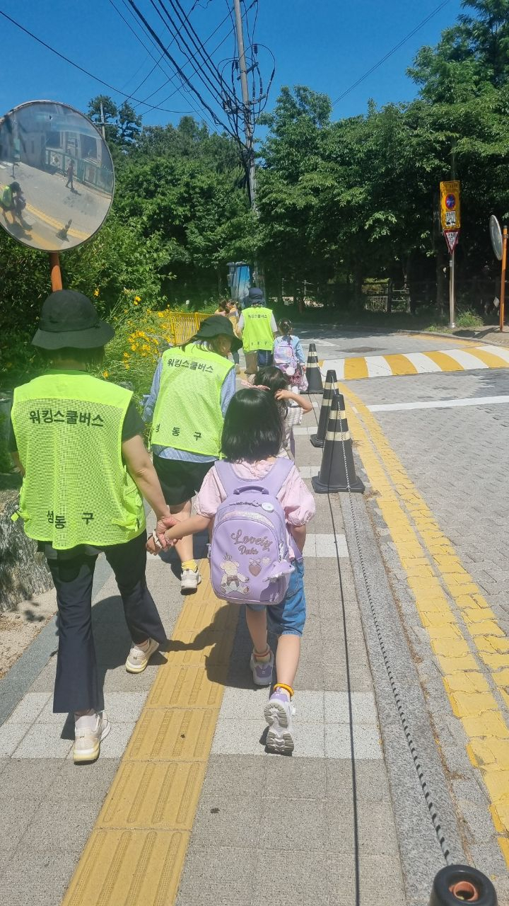 서울 성동구는 교통안전지도사가 통학길 안전을 돌봐주는 워킹스쿨버스 사업을 방학 기간에도 운영한다. 사진은 교통안전지도사의 워킹스쿨버스 활동.[성동구 제공]