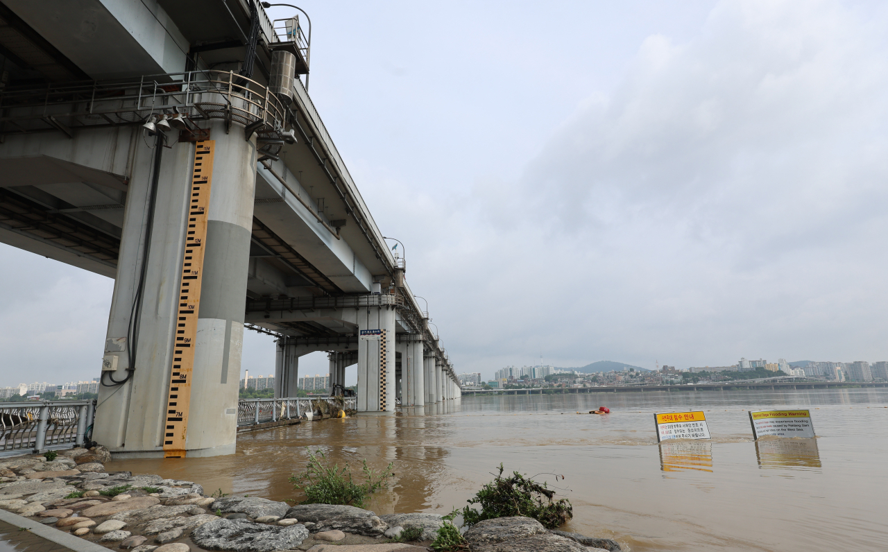 19일 오전 중부지역 집중호우로 차량과 보행자 통행이 통제됐던 서울 잠수교를 미화원들이 청소하고 있다. [연합]