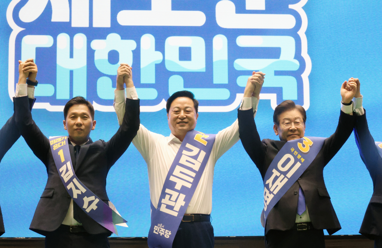 더불어민주당 새 지도부 선출을 위한 전당대회를 앞두고 20일 제주시 한라체육관에서 열린 합동연설회에서 김지수·김두관·이재명 대표 후보(왼쪽부터)가 손을 맞잡고 포토타임을 갖고 있다. [연합]