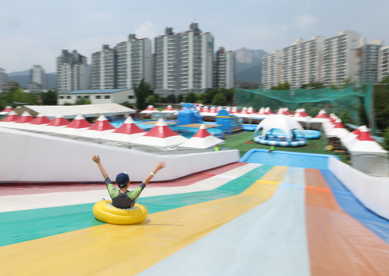 서울 도봉구 성균관대 야구장 부지에 설치된 2024 도봉 썸머 워터랜드 물놀이장을 찾은 어린이가 물썰매를 타고 있다. [연합]