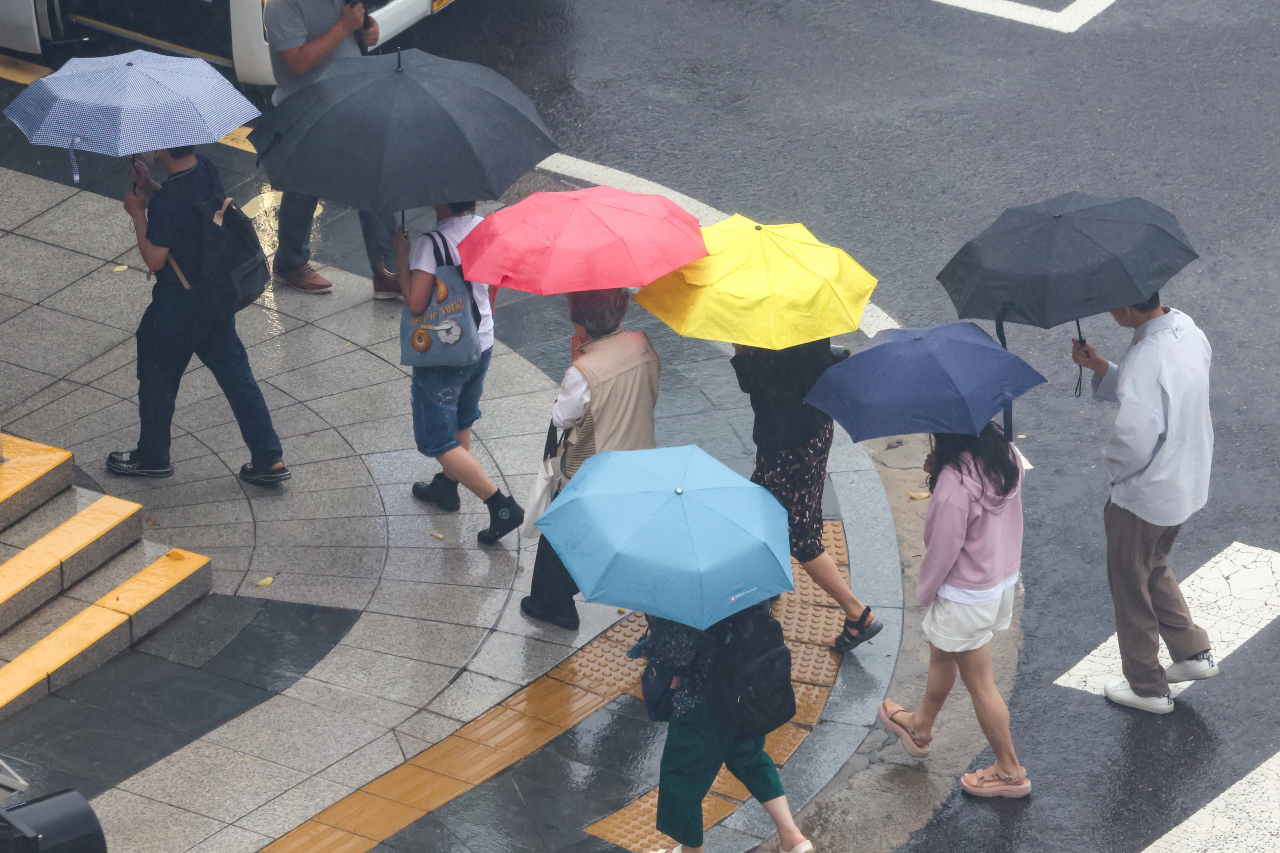 비가 내린 22일 오후 서울 시내 한 대형병원에서 내원객들이 우산을 쓰고 이동하고 있다. [연합]