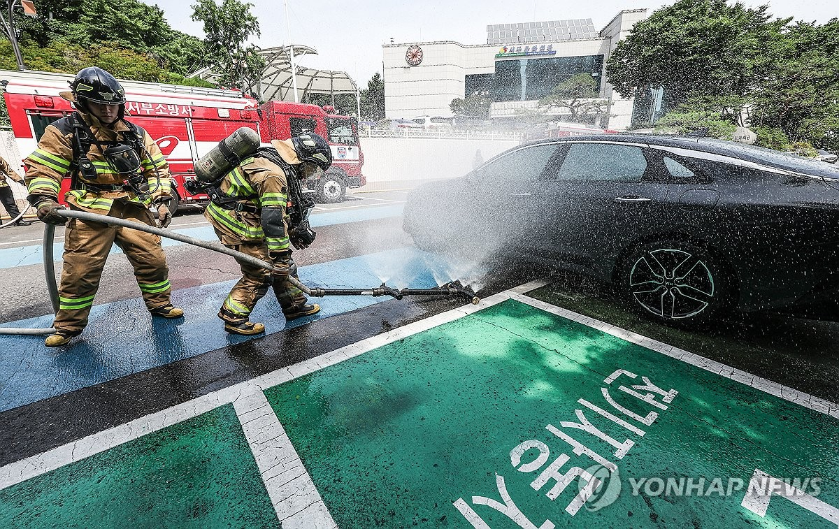 26일 대구 서구 이현동 대구서구문화회관에서 진행된 전기차 화재 대응 훈련에서 대구서부소방서 소방관이 상방방사장치를 사용해 불을 끄는 훈련을 하고 있다. [연합]