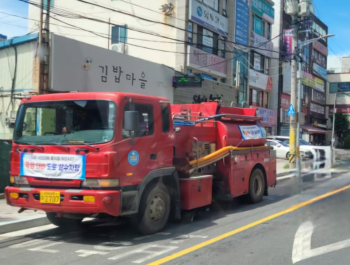 부산 기장군의 한 도로에서 살수차가 운행하며 도로의 열기를 식히고 있다. [사진=기장군]