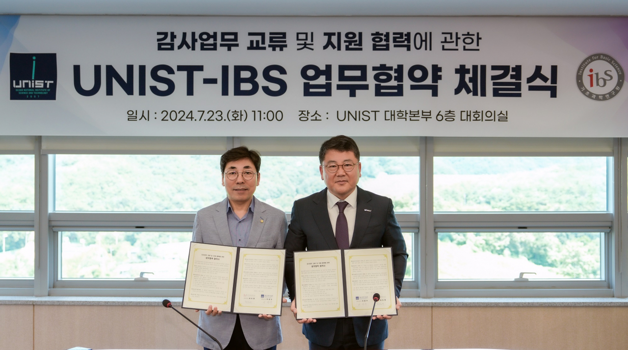최도영 IBS 상임감사(왼쪽)와 이광우 UNIST 상임감사 협정서를 들고 기념사진을 촬영하고 있다.[UNIST 제공]