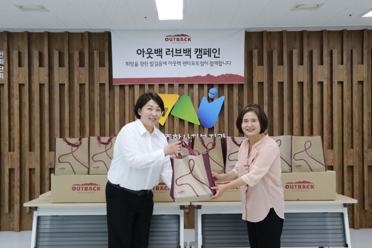 아웃백 천안펜타포트점 박금석(왼쪽) 점주와 천안시종합사회복지관 문명희 관장이 기념사진을 촬영하고 있다. [아웃백 스테이크하우스 제공]