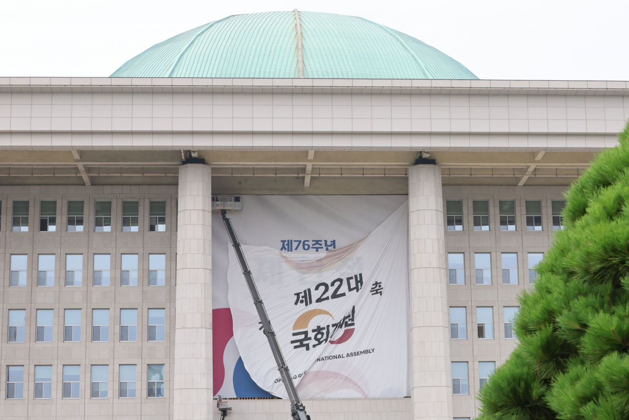 서울 여의도 국회의사당 본관에 설치된 제22대 국회 개원 현수막이 지난 7일 오후 철거되고 있다. 5일 열릴 예정됐던 22대 국회 개원식은 ‘채해병특검법’을 둘러싼 여야 충돌의 여파로 무기한 연기됐다. [연합]