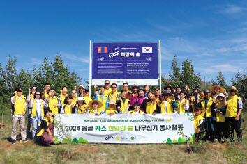 오비맥주 임직원과 봉사단이 24일 몽골 ‘카스 희망의 숲’기념 현판 앞에서 나무심기 봉사활동을 마치고 기념촬영을 하고 있다. [오비맥주 제공]