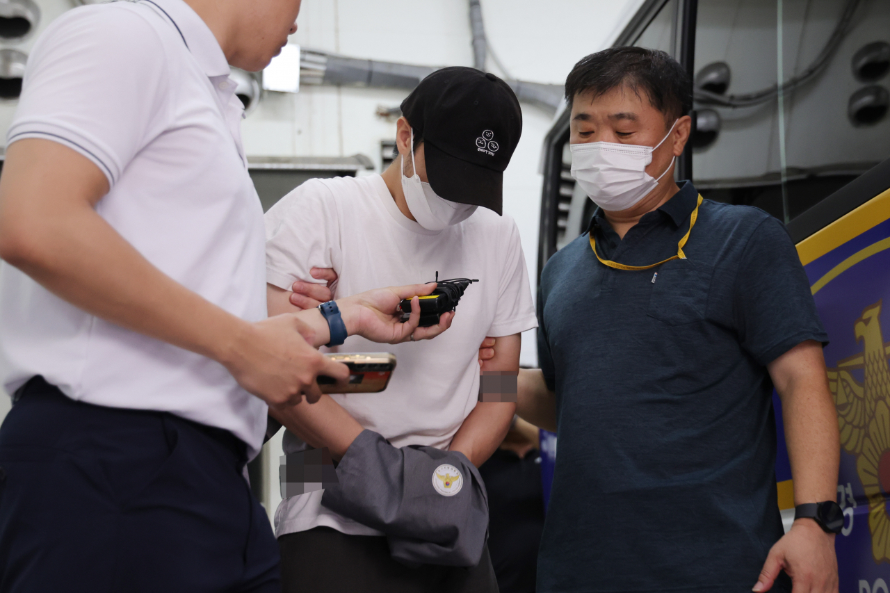 19일 오전 경기 의정부경찰서에서 경찰이 관원인 5세 아동을 심정지 의식불명 상태에 빠지게 한 혐의로 구속된 태권도 관장 A씨를 의정부지검으로 송치하고 있다. [연합]