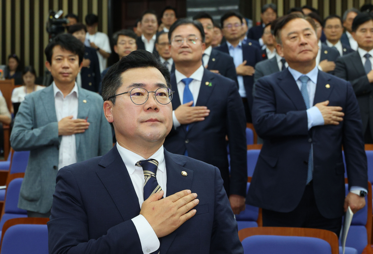 박찬대(앞줄 가운데) 더불어민주당 당대표 직무대행 겸 원내대표가 25일 국회에서 열린 의원총회에서 국민의례를 하고 있다. [연합]