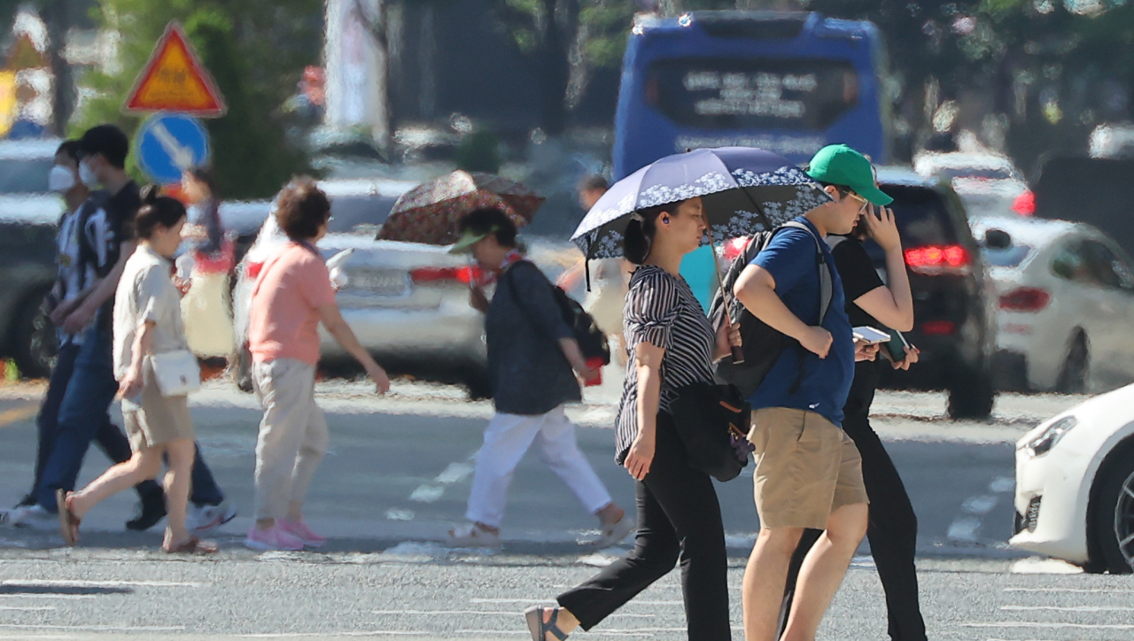 폭염주의보가 발효 중인 25일 오후 해운대구 한 도로 위로 지열로 인한 아지랑이가 피어오르고 있다. 이날 부산의 낮 최고기온은 35도를 기록했다. [연합]