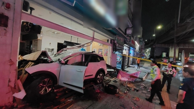 28일 오전 1시25분께 부산 남구 문현동 한 도로에서 60대 A씨가 몰던 택시가 인도를 지나 상가 건물로 돌진하는 사고가 났다. 사고 택시가 심하게 구겨져 있다. [부산 남부경찰서 제공]