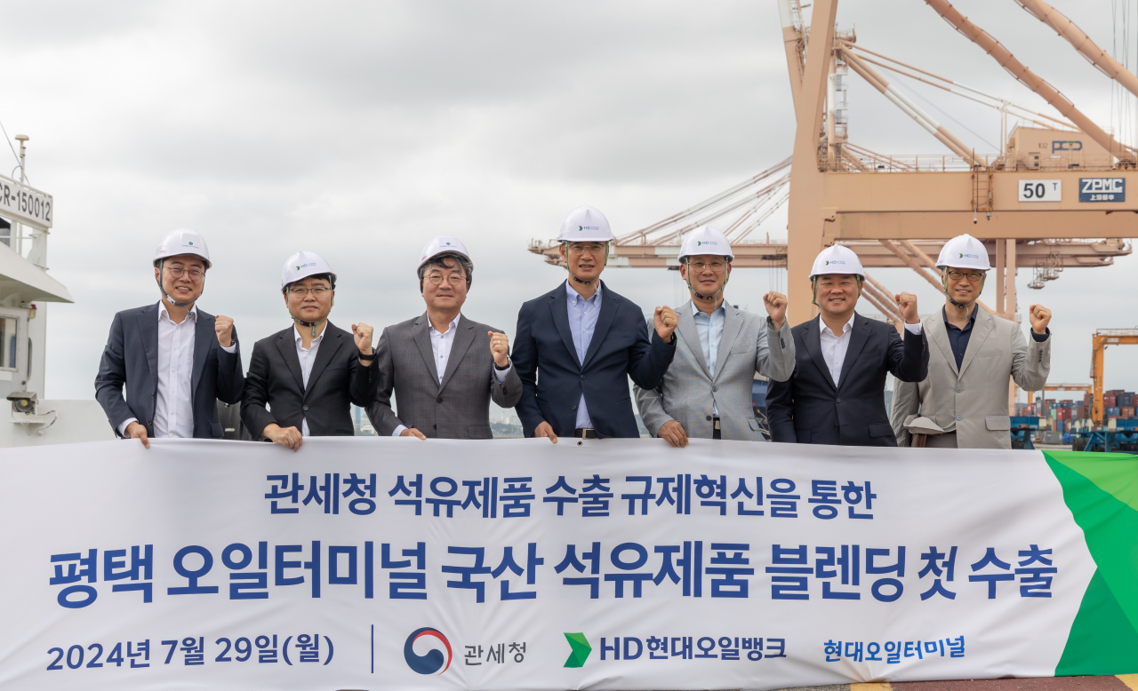 블렌딩 수출 현장에 참석한 이승수(왼쪽 4번째) HD현대오일뱅크 글로벌 사업본부장과 고석진(왼쪽 5번째) 관세청 통관국장 등이 기념사진을 찍고 있다. [HD현대오일뱅크 제공]