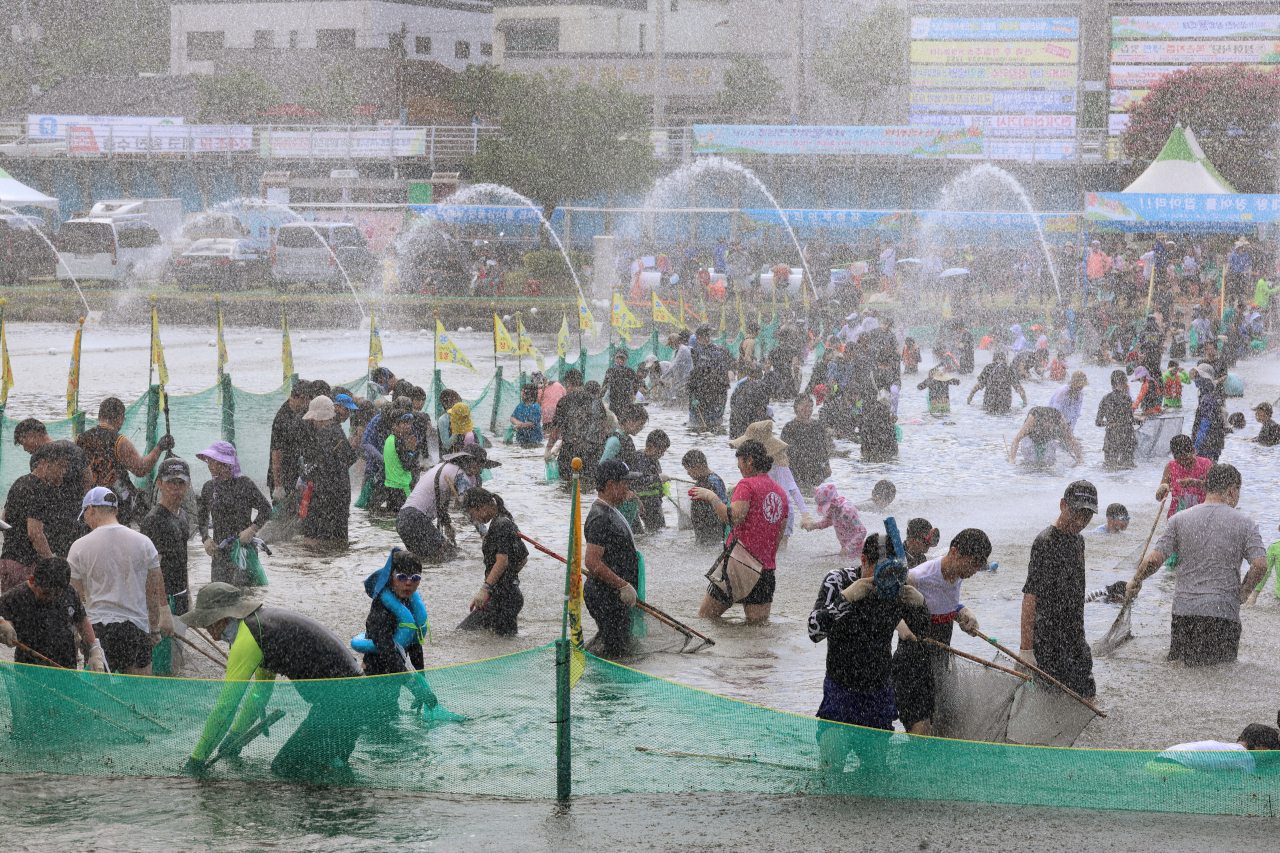 29일 전남 장흥에서 열린 제17회 정남진 장흥 물축제에서 관광객과 시민들이 '황금물고기(대왕장어) 잡아라'에 참여해 무더위를 식히고 있다. 'ALL 水 좋다-신나는 장흥 물축제'란 슬로건 아래 펼쳐지는 이번 축제는 다음 달 4일까지 열린다. [연합]