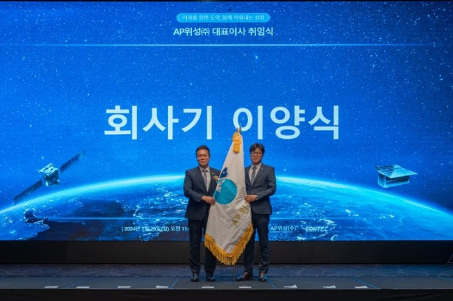 이성희 AP위성 대표이사가 송진환 전무에게 회사기를 전달 받고 있다. [AP위성]