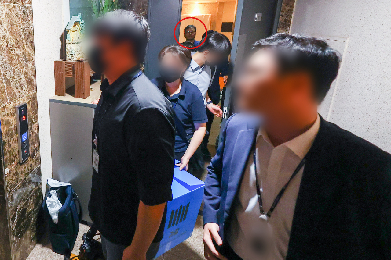티몬과 위메프의 대규모 정산 지연 사태를 수사하는 검찰 관계자들이 1일 구영배 큐텐그룹 대표(빨간색 원 안) 자택 압수수색을 마친 뒤 압수품 박스를 들고 떠나고 있다. [연합]