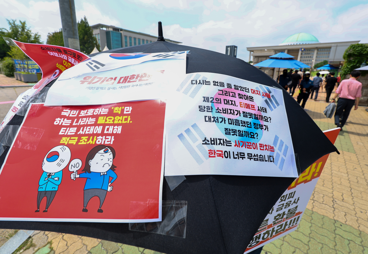 큐텐 구영배 대표, 류광진 티몬 대표, 류화현 위메프 대표 등이 국회 정무위 현안질의에 출석한 지난달 30일 오후 국회 앞에서 티몬·위메프 정산지연 사태 피해자가 팻말을 들고 1인 시위를 하고 있다. [연합]