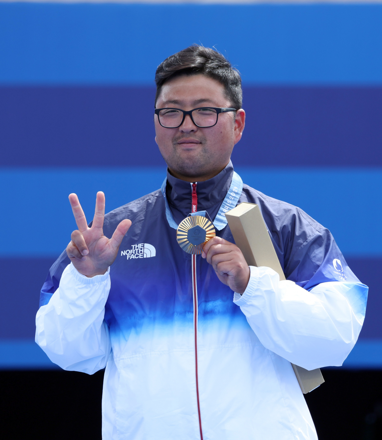 한국 양궁 대표팀 김우진이 4일 오후(현지시각) 프랑스 파리 앵발리드 경기장에서 열린 2024파리올림픽 양궁 남자 개인전에서 시상대에 올라 3관왕 손가락 모양을 하고 있다. 오른쪽은 동메달을 차지안 이우석.김우진은 남자 단체전, 혼성 단체전까지 더해 3관왕이라는 새 이정표를 세웠다. [파리=이상섭 기자]