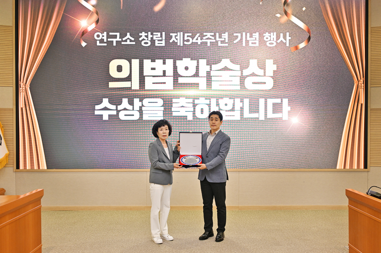 국방과학연구소 창립 54주년 기념식에서 고(故) 김용철 옹의 장녀인 김설매(왼쪽) 여사가 이수용(오른쪽) 선임연구원에게 상패를 전달하고 있다.[국방과학연구소 제공]