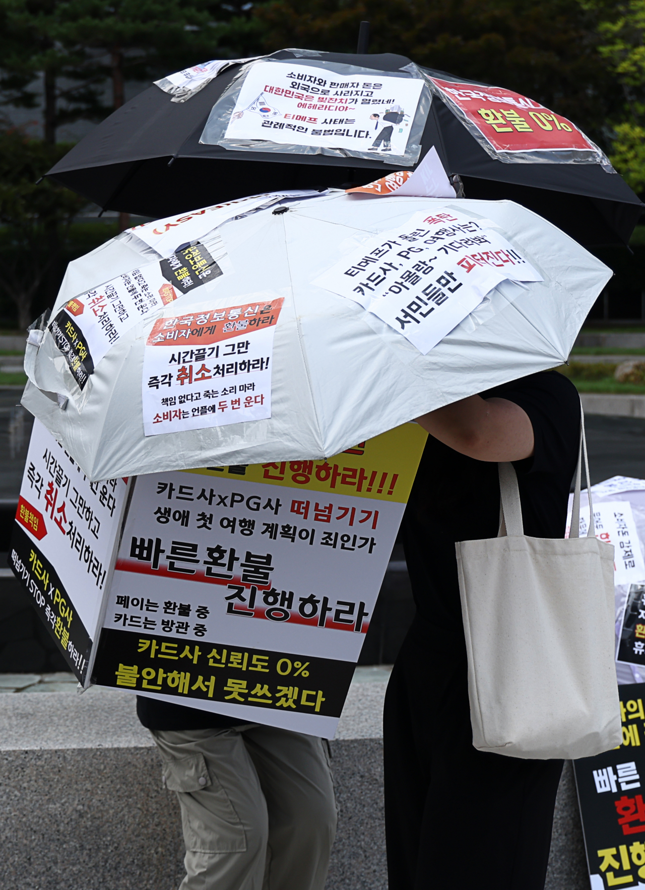 티몬·위메프(티메프) 피해자가 4일 오후 서울 중구 대한상공회의소 인근에서 환불 등을 촉구하는 릴레이 우산 시위를 진행하고 있다. [연합]