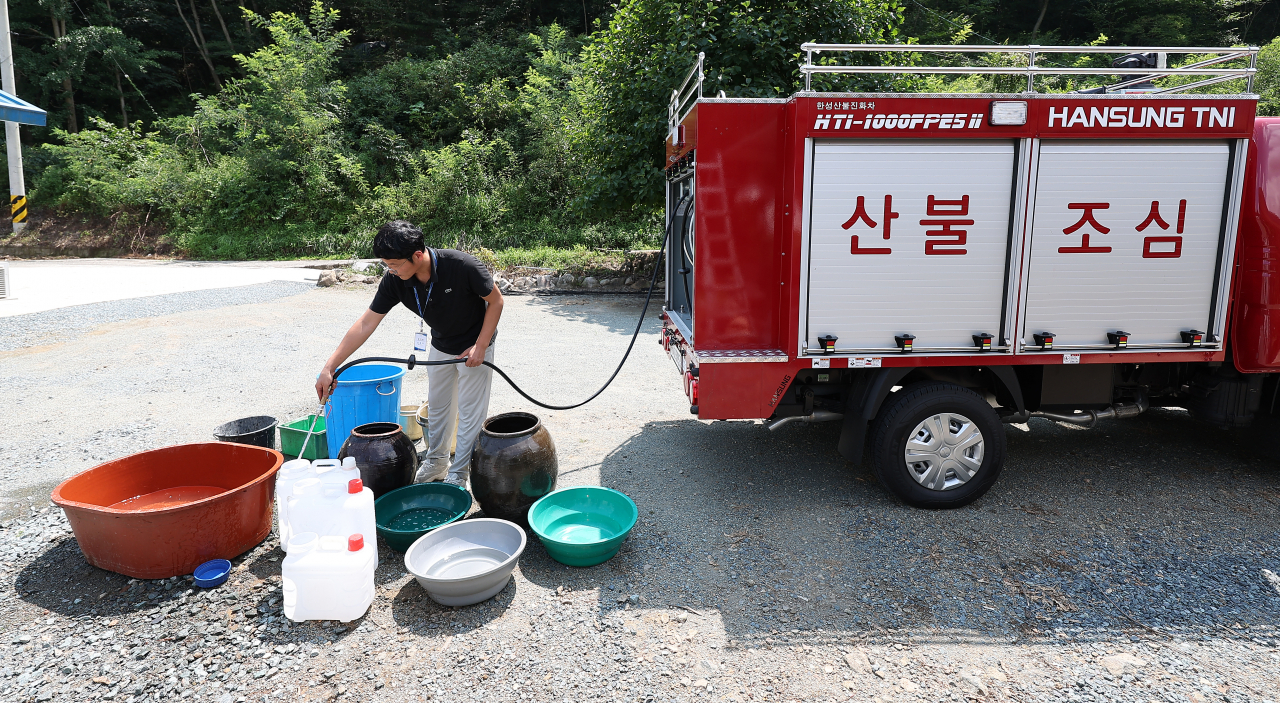 5일 경북 청도군 풍각면 한 가정집이 단수된 가운데 풍각면사무소 직원이 급수 지원을 하고 있다. 청도군은 전체 물 사용량이 생산량을 넘어서면서 전날 오후부터 일부 지역에서 물을 사용하지 못하고 있다.[연합]