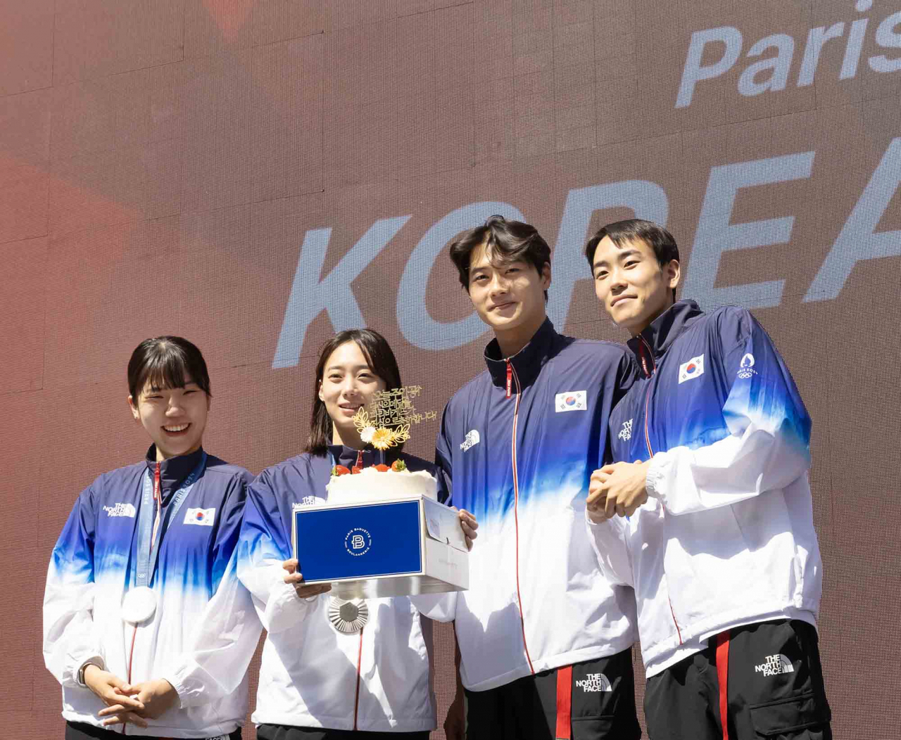 현지시각 4일 프랑스 파리 코리아하우스에서 열린 국가대표 메달리스트 기자회견 행사에 참석한 선수들이 파리바게뜨 케이크를 들고 축하받는 모습. [SPC 파리바게뜨 제공]