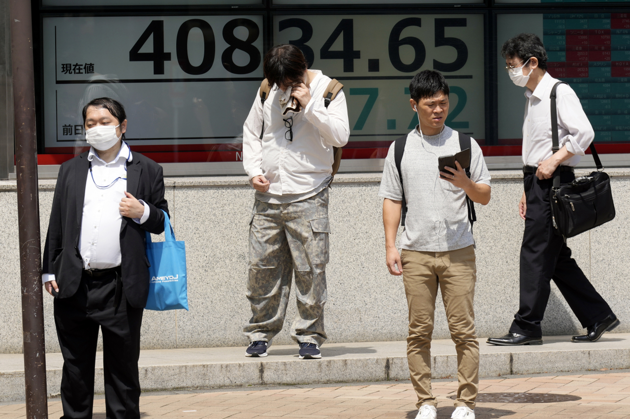 지난달 8일(현지시간) 일본 도쿄의 한 증권사에서 시민들이 일본 닛케이225지수를 보여주는 전광판 앞에 서 있다. [AP]